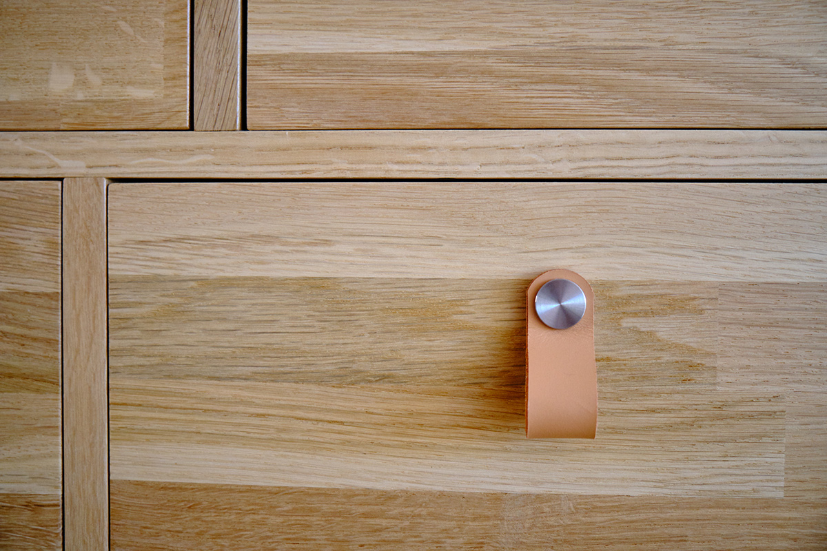 Détail meuble de rangement à tiroirs mercerie, poignées cuir