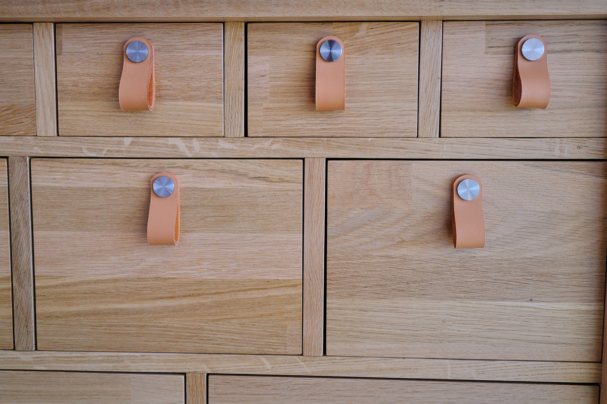Détail meuble de rangement à tiroirs mercerie, poignées cuir